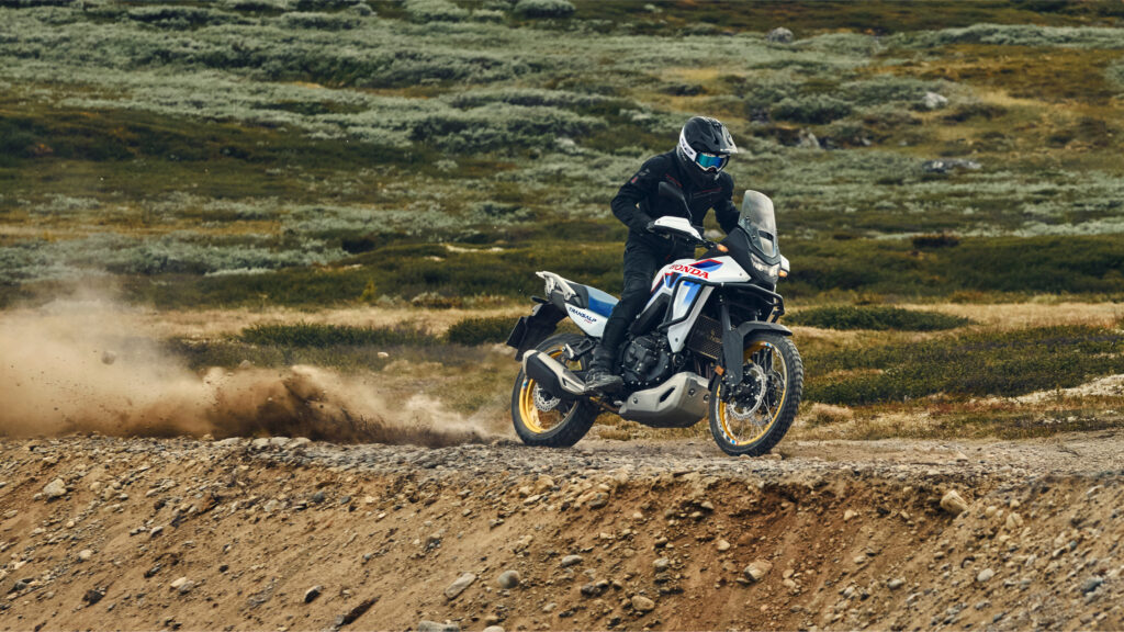 Honda XL750 Transalp sur piste de terre, gerbe de poussière