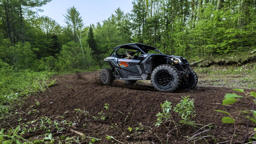 Can-Am Maverick X3 X Turbo gris sur chemin de terre, en appui