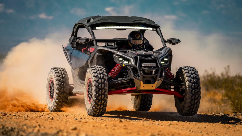 Can-Am Maverick X3 X RS bleu nuit en saut sur piste de terre