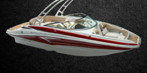 Bateau Crownline E 235 blanc et rouge, trois quarts avant sur fond sombre