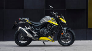 Honda CB750 Hornet jaune, trois quarts avant, devant un mur sombre