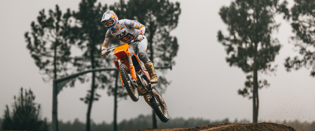KTM 450 SX-F en saut sur un terrain de motocross, pilote en tenue de compétition