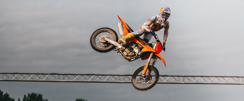 KTM 450 SX-F en saut au-dessus d'une table, pilote en position