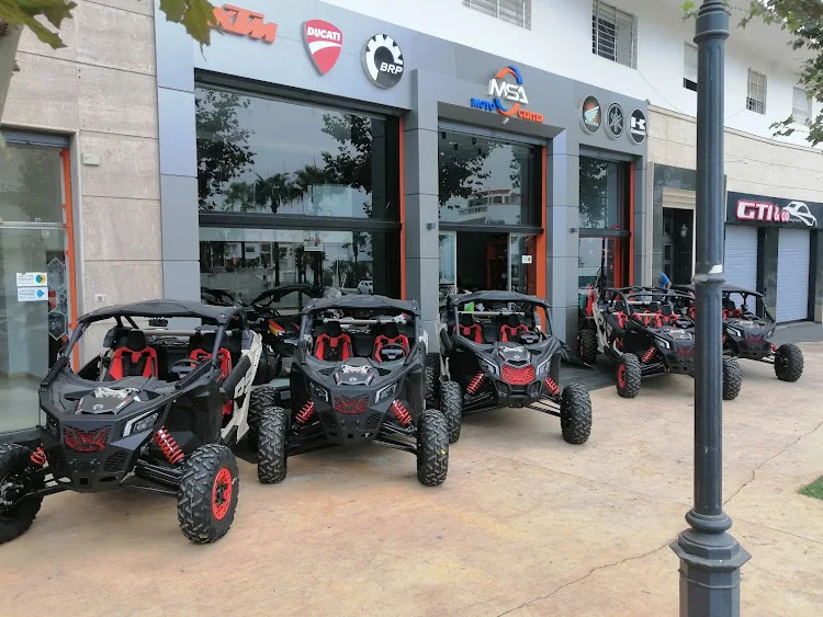 Quatre SSV alignés sur le trottoir devant la vitrine du magasin MSA Moto Center