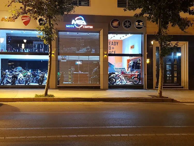 Le magasin MSA Moto Center vu depuis la rue de nuit, enseigne allumée et vitrines éclairées présentant les motos