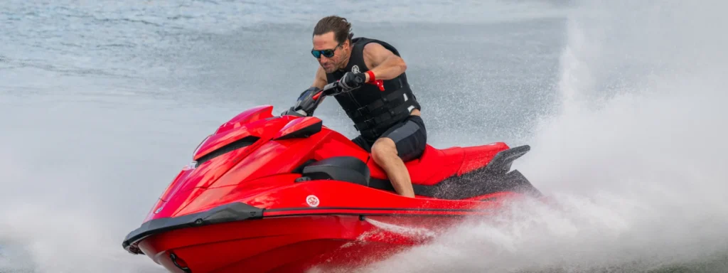 Jet-ski Yamaha GP1800R SVHO rouge lancé sur un plan d'eau, gerbe d'écume