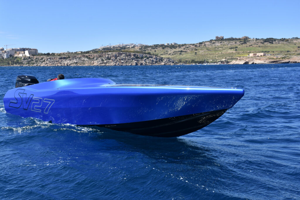 Chaudron SV 27 à coque bleue naviguant près de la côte