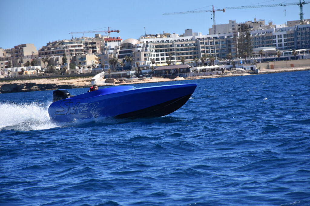 Chaudron SV 27 bleu lancé à pleine vitesse devant le front de mer