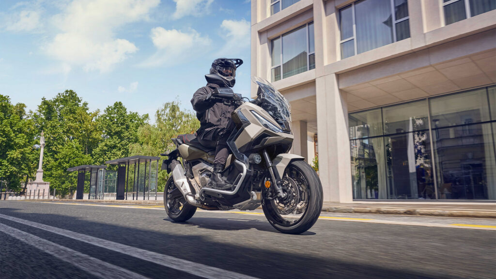Pilote casqué au guidon d'un Honda X-ADV 750 dans une rue en ville