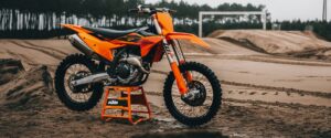 KTM 250 SX-F 2027 sur une béquille KTM au bord d'une piste de motocross sablonneuse