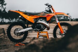 KTM 300 SX 2027 sur une béquille KTM, vue de profil côté droit, sur une piste de motocross