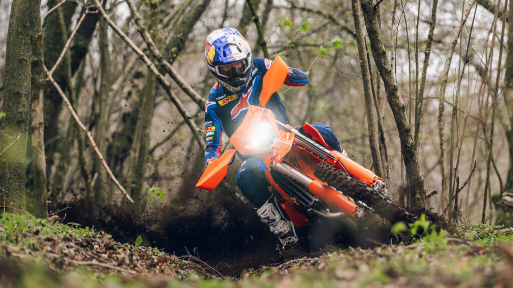 KTM 500 EXC-F 2027 en virage dans un sous-bois, gerbe de terre, pilote Red Bull KTM Factory Racing