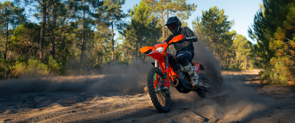 KTM 500 EXC-F Six Days 2027 en virage dans le sable, gerbe de sable
