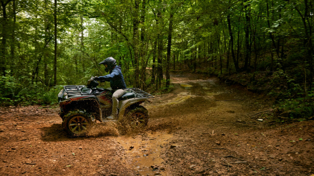 Yamaha Grizzly 700 EPS XT-R en virage sur un chemin de terre en forêt